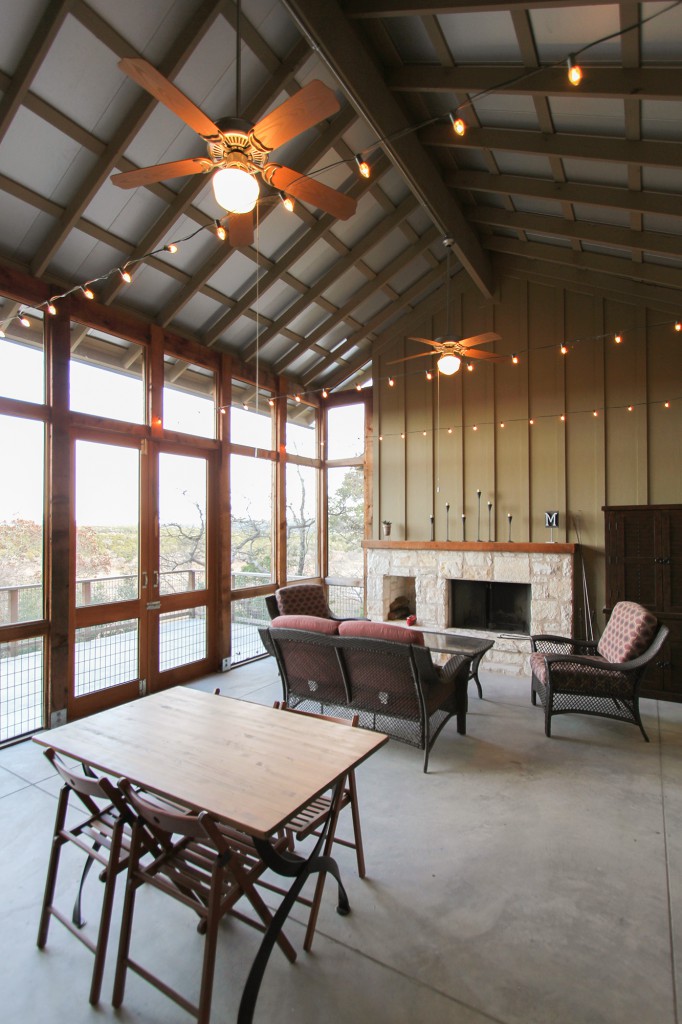 Screened porch with view. Metal roof, cable lights, fireplace, and concrete floors. 