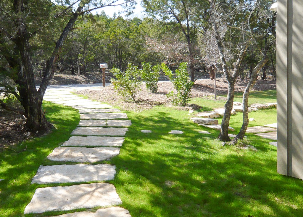 Front walk are rustic natural limestone steps set along a curving path.