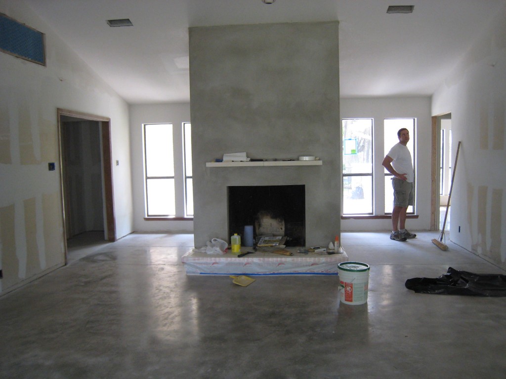 View of fireplace and new concrete floor. Wall opened up.