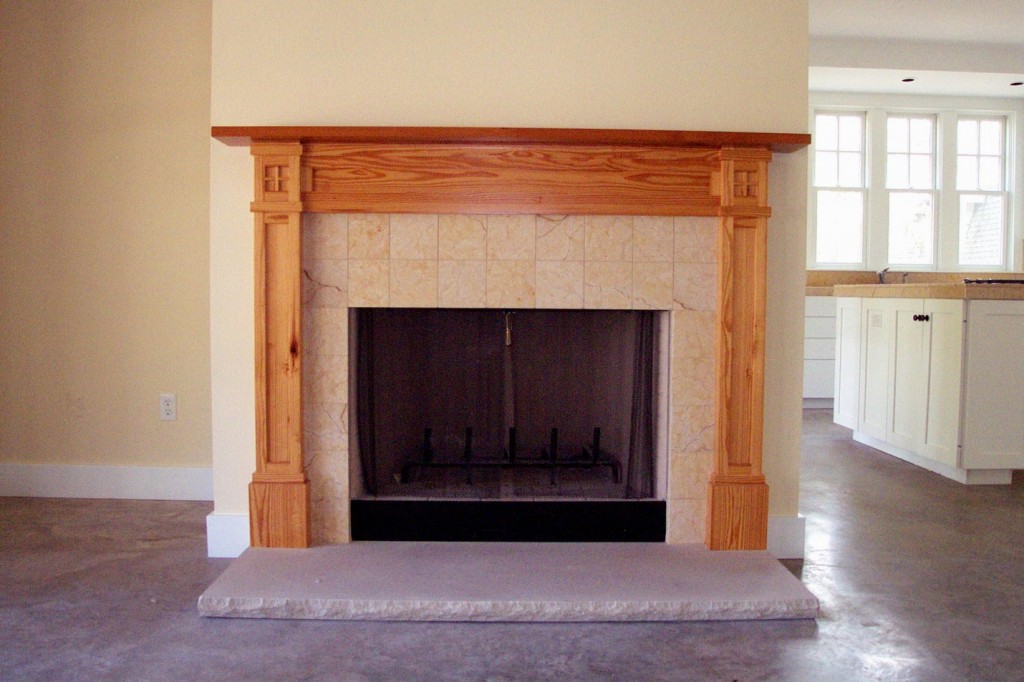 Antique pine mantel on fireplace in modern craftsman style house.