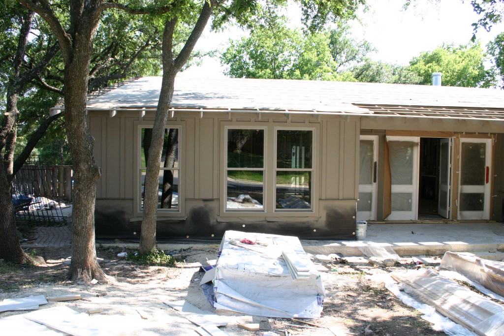 View of ranch style house under construction. Siding and doors are in.