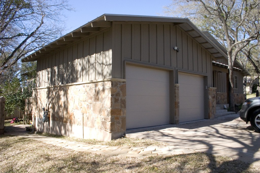 Two car garage with board and batten siding and gray flagstone.