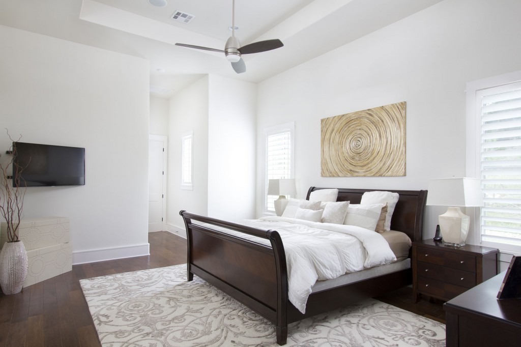 Transitional style master bedroom with wood floors, white walls.