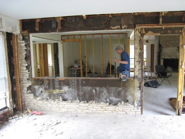View of torn down window and stone wall in old sun room.