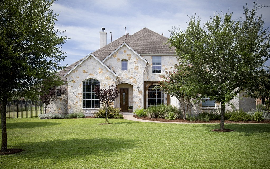 Austin home exteriors. Texas limestone traditional on large lot.