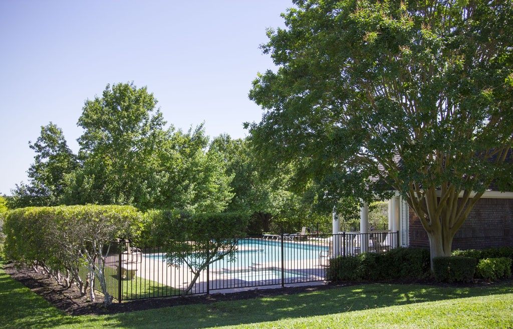 Small gated pool for lap swimming nestled behind trees in heart of neighborhood.