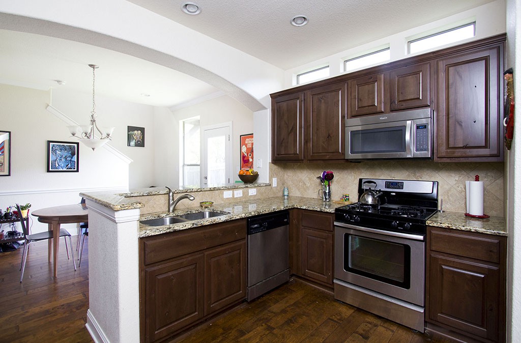 View of kitchen with Alder cabinets, wood floors, granite counters. 