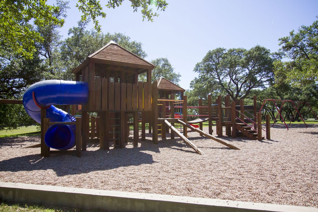 Playground equipment - slides, swings, climbing equipment, playhouse.