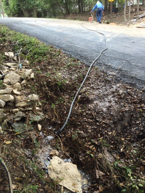 Siphoning water away from driveway to dry out the path for concrete trucks.