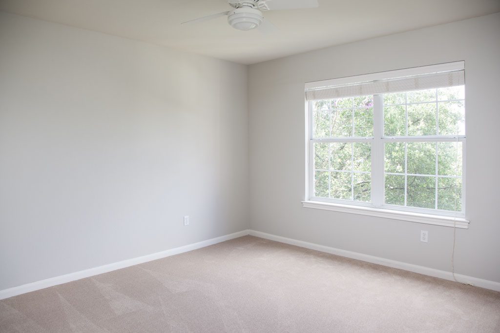 2nd Bedroom upstairs is spacious room with view of trees in font yard.