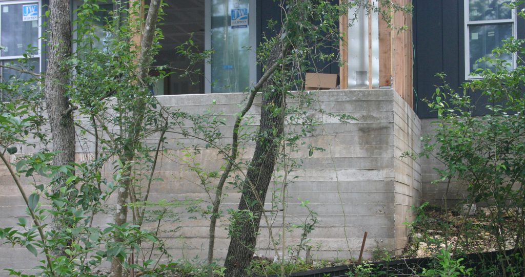 Board-formed concrete foundation on modern farmhouse in Lake Hills neighborhood.