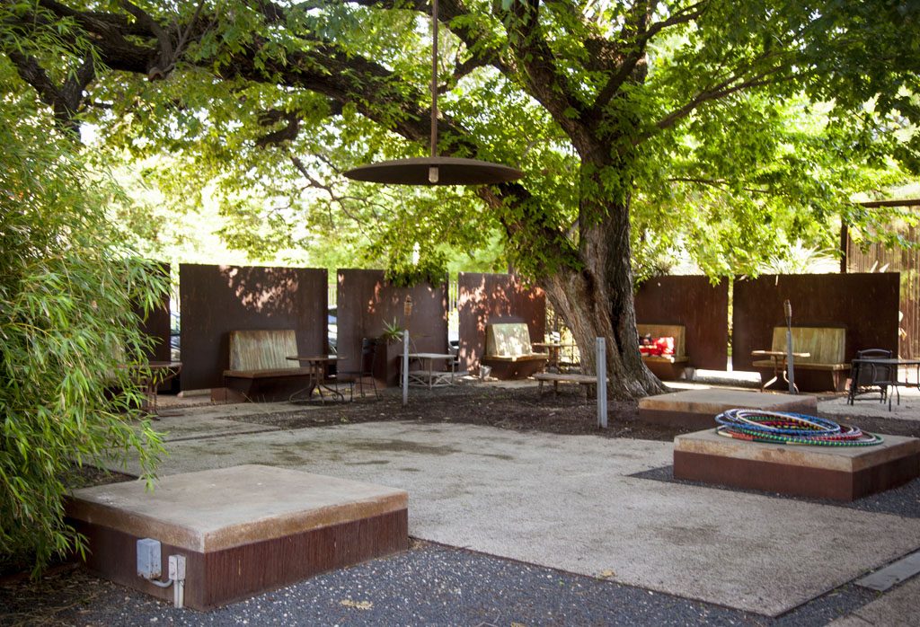 Pedernales Condo shady gathering area for residents to enjoy outdoors under large trees.