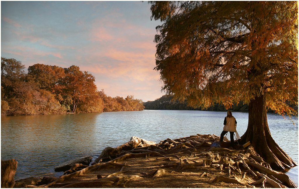 An artist painting on Lady Bird Lake at sunset.