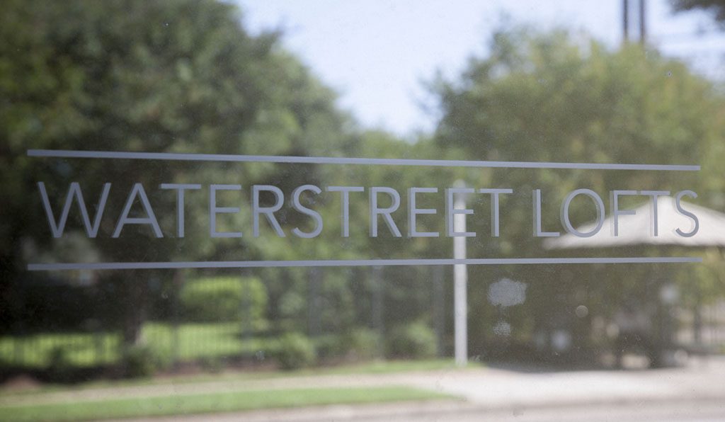 Waterstreet Lofts sign reflected in a glass window in central East Austin.