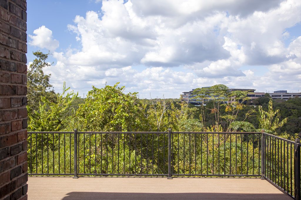 View of hill country and Blacones Preserve from deck at River Place home.