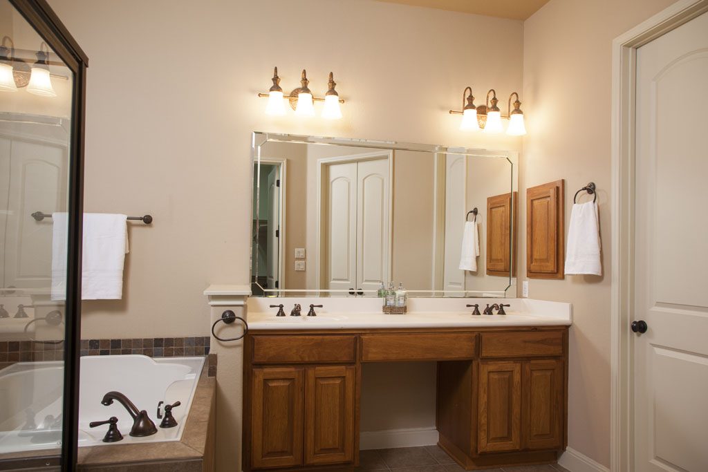 View of double vanity with dark wood cabinetry in master bath.