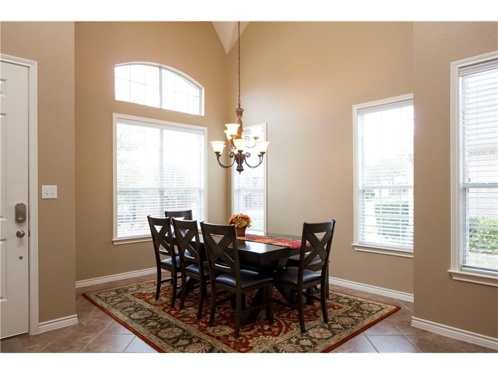 Vie w of formal dining with tall ceilings and tile floors.