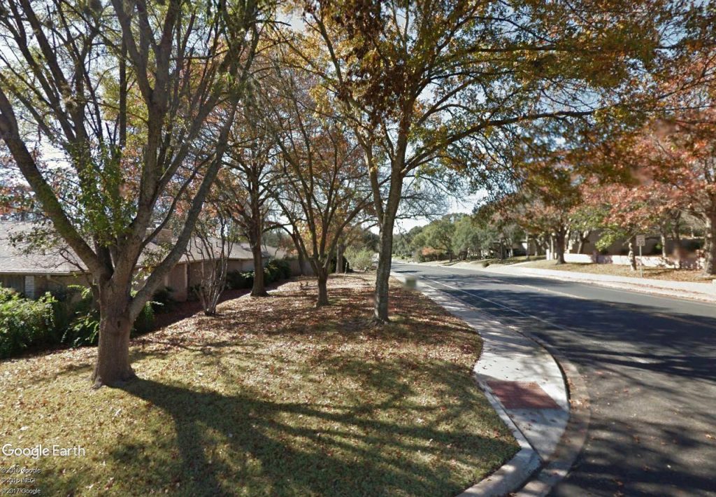 real estate north central Austin view of shady winding street in Northwest Hills.