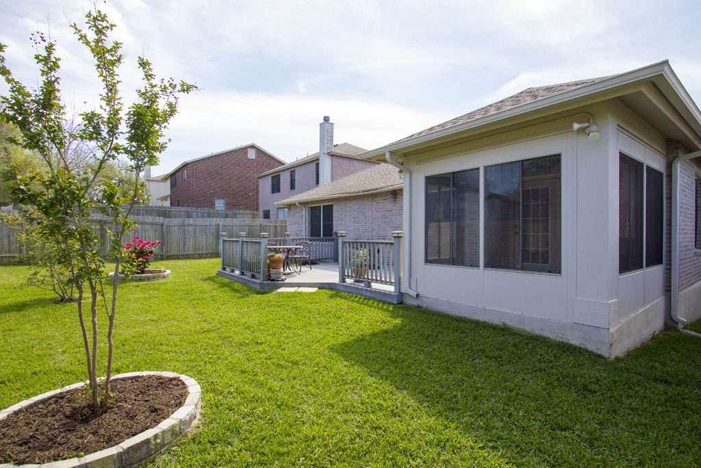 Spacious green back yard is perfect for soccer, gardening, and outdoor play.