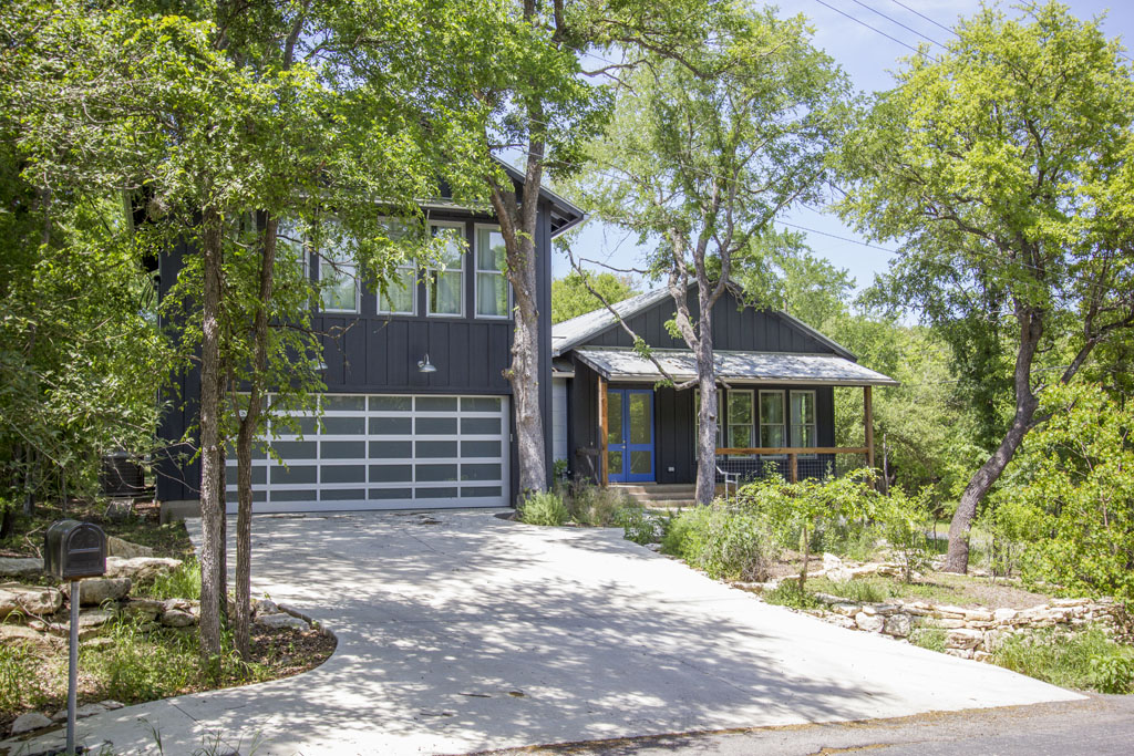 View of native trees surrounding contemporary farmhouse home. Austin Lake Hills Lease home. 